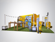 Outdoor-themed exhibit booth design with string lights and turf